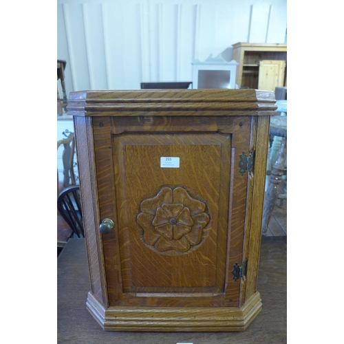 255 - A small carved oak hanging corner cupboard