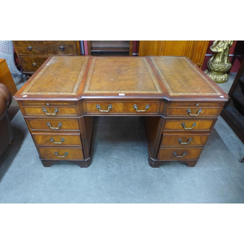 86 - A mahogany and brown leather topped breakfront library desk