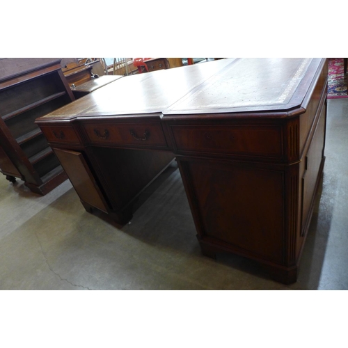 86 - A mahogany and brown leather topped breakfront library desk