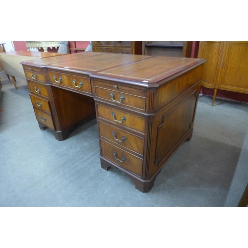 86 - A mahogany and brown leather topped breakfront library desk