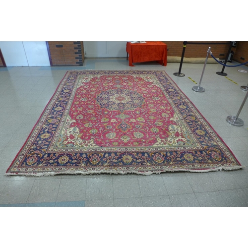 90 - A large red ground geometric patterned rug, 405 x 310cms