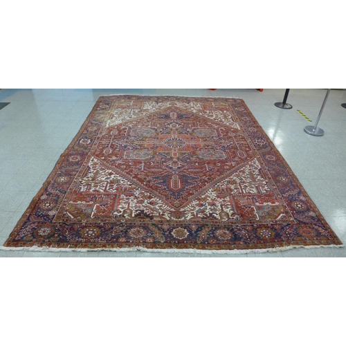 92 - A large red ground geometric patterned rug, 375 x 295cms