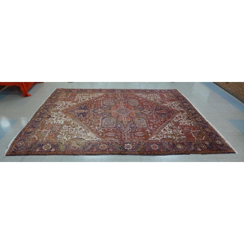 92 - A large red ground geometric patterned rug, 375 x 295cms