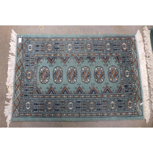 94 - A Pakistani hand knotted Bokhara green ground prayer rug, 98 x 66cms