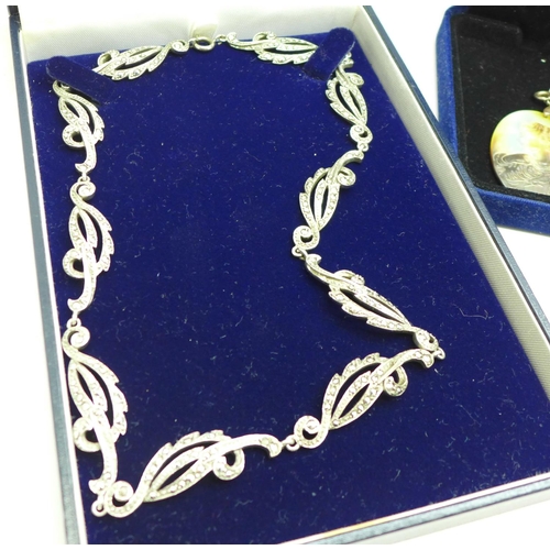 1005 - A silver and marcasite necklace, a silver and pearl necklace and earrings, and two silver pendants