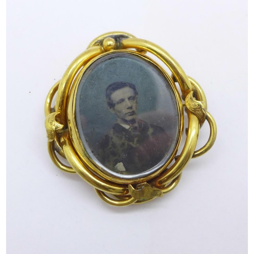 1008 - A Victorian gold plated swivel brooch, (with early photograph of a gentleman and a later image of a ... 