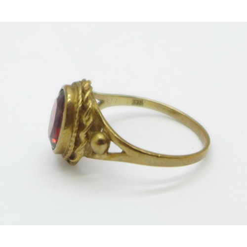 1053 - A 9ct gold red stone ring, 2.7g, O