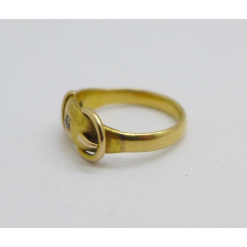 1071 - A yellow metal buckle ring set with a diamond and a sapphire, 4.7g, N