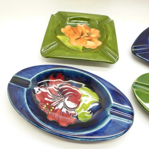 757 - Moorcroft, four ashtrays in various Hibiscus patterns, all circa 1940-50s, a triangular ashtray, app... 