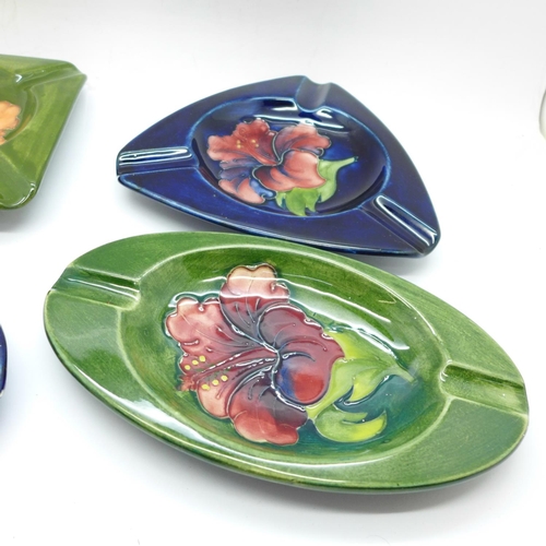 757 - Moorcroft, four ashtrays in various Hibiscus patterns, all circa 1940-50s, a triangular ashtray, app... 