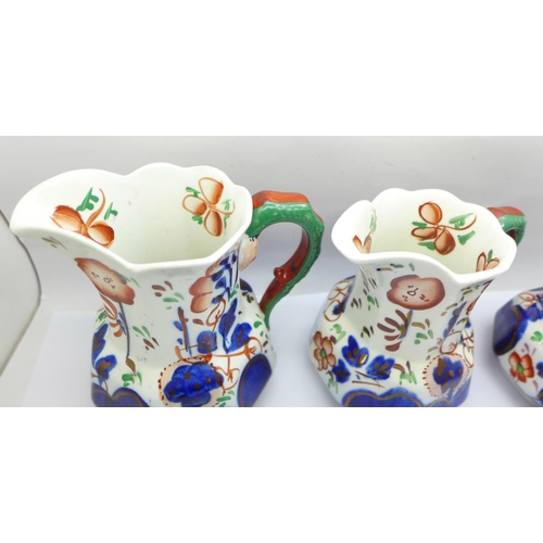 758 - A group of three graduated hand painted jugs decorated in the Gaudy Welsh style, circa 1920, 10cm to... 