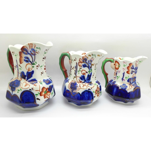 758 - A group of three graduated hand painted jugs decorated in the Gaudy Welsh style, circa 1920, 10cm to... 