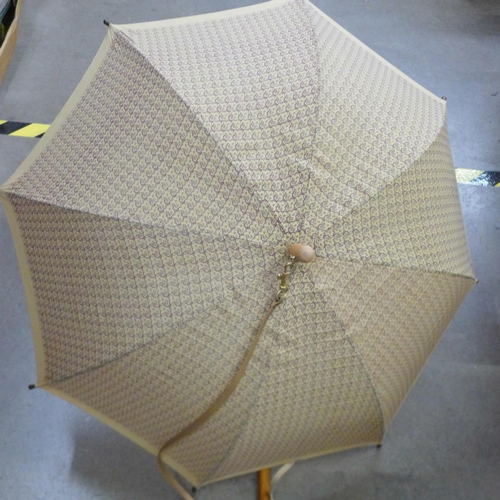 842 - An umbrella and a silver topped cane