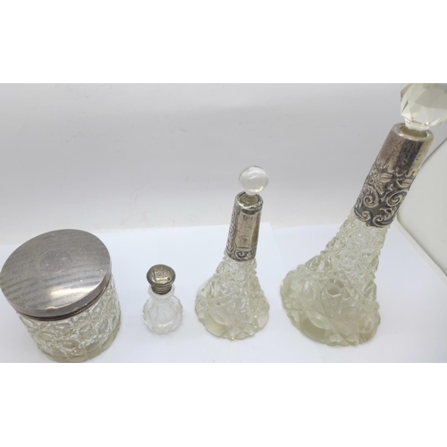 851 - Three silver topped glass scent bottles and a silver topped glass jar