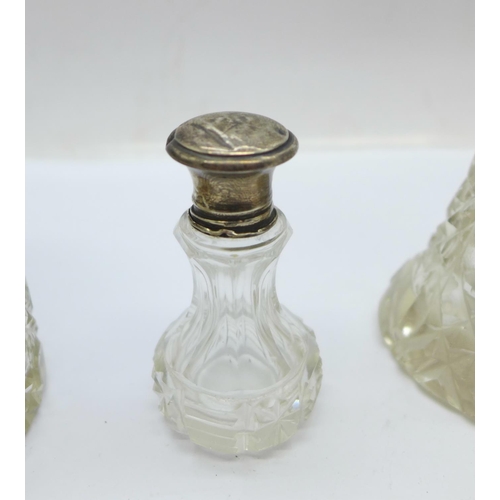 851 - Three silver topped glass scent bottles and a silver topped glass jar