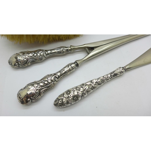 854 - An Art Nouveau silver backed hair brush, silver handled glove stretchers and a similar shoe horn