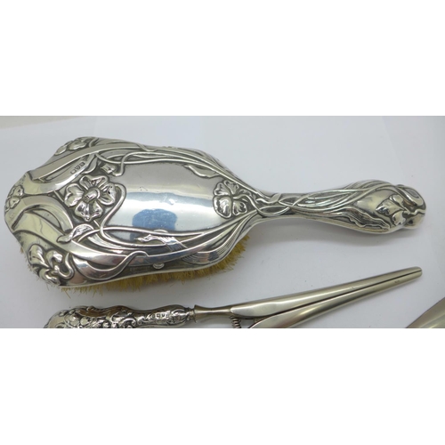 854 - An Art Nouveau silver backed hair brush, silver handled glove stretchers and a similar shoe horn