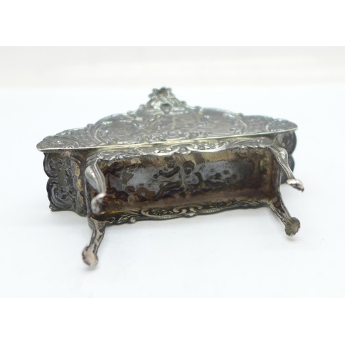 900 - A hallmarked silver dolls house settee with embossed cherubs, London mark, 17g, 62mm wide