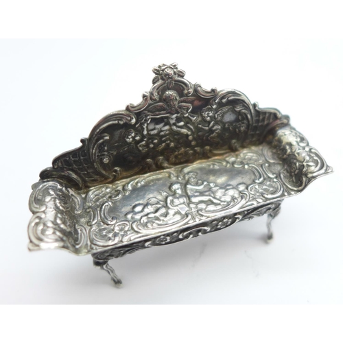 900 - A hallmarked silver dolls house settee with embossed cherubs, London mark, 17g, 62mm wide