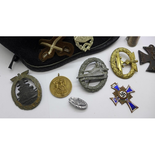 952 - Three German WWII period badges, two lacking hooks, a 1936 tinnie badge, a mothers cross medal, a/f,... 