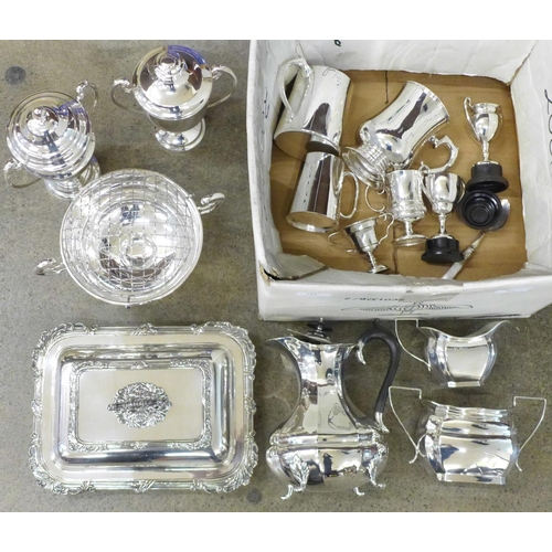 724 - A box of silver plated items, rose bowl, four trophies, three piece tea service, tankards, etc.