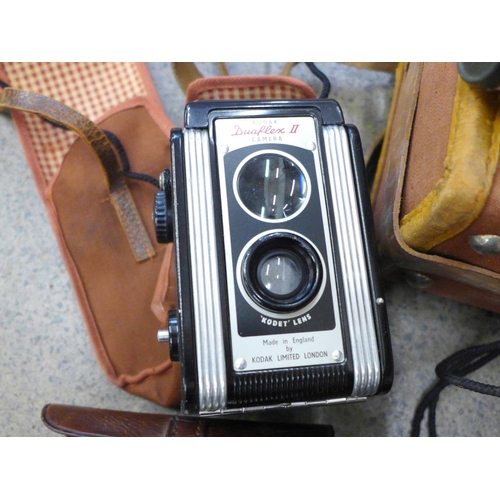 734 - A collection of cameras and binoculars, Kodak Dualflex II, Yashinin F1.4 38mm lens, boxed, etc.