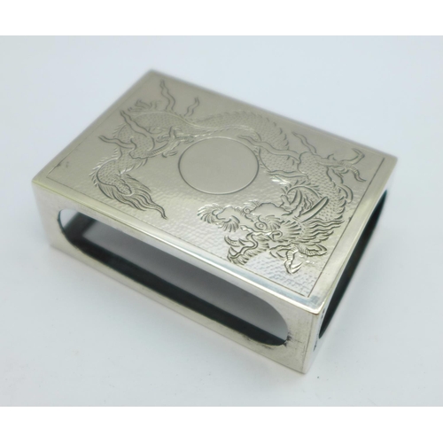 920 - An oriental white metal matchbox cover decorated with a dragon, with control marks