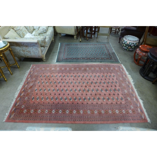 147 - A salmon ground rug and a turquoise ground rug