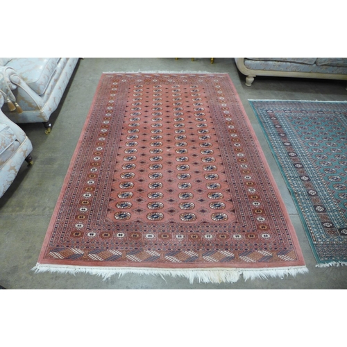 147 - A salmon ground rug and a turquoise ground rug