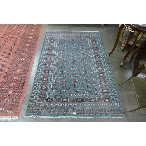 147 - A salmon ground rug and a turquoise ground rug