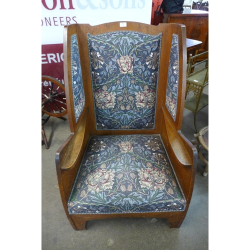 151 - An Arts and Crafts Ambrose Heal oak cottage range armchair, upholstered in William Morris style fabr... 