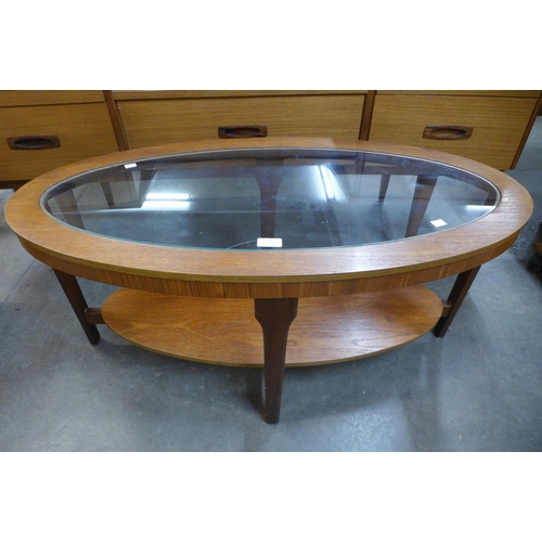 200 - A teak and glass topped oval coffee table