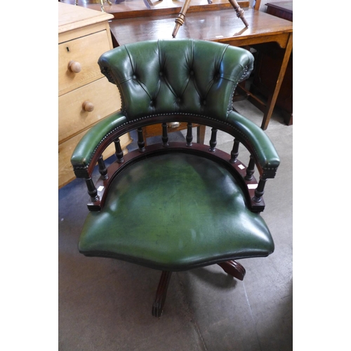 220 - A mahogany and green leather revolving desk chair