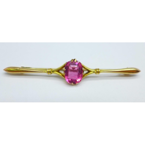 1034 - Two 9ct gold brooches; horseshoe with red stone and one set with a pink stone, total weight 3.1g