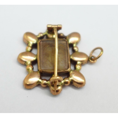 1037 - A rolled gold and garnet mourning pendant/brooch, lacking one stone