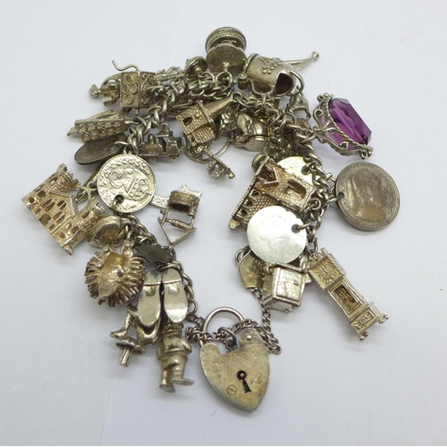 1128 - A silver charm bracelet, each link marked, 110g