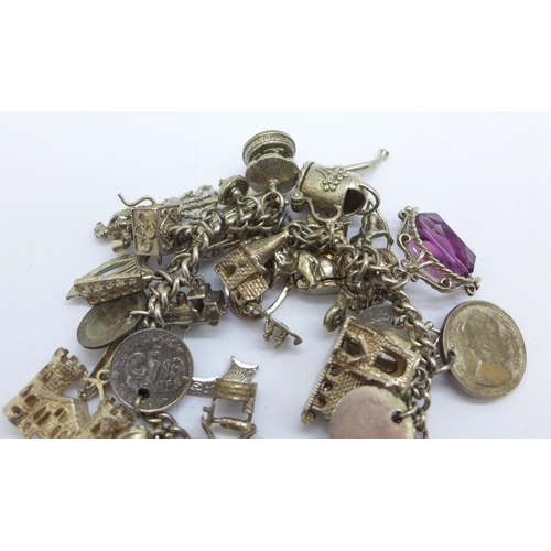 1128 - A silver charm bracelet, each link marked, 110g