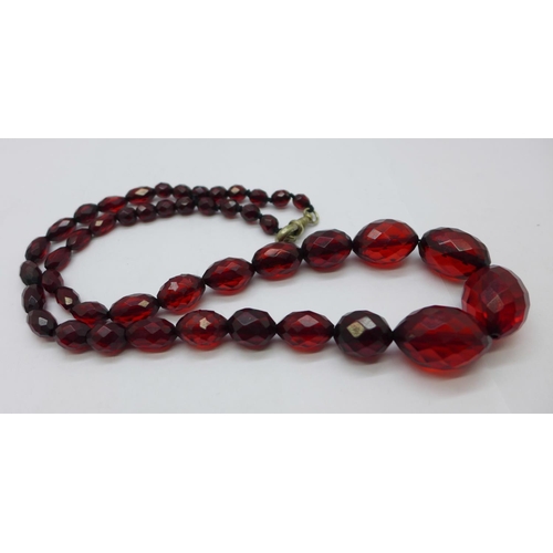 1185 - A string of faceted sherry amber coloured beads