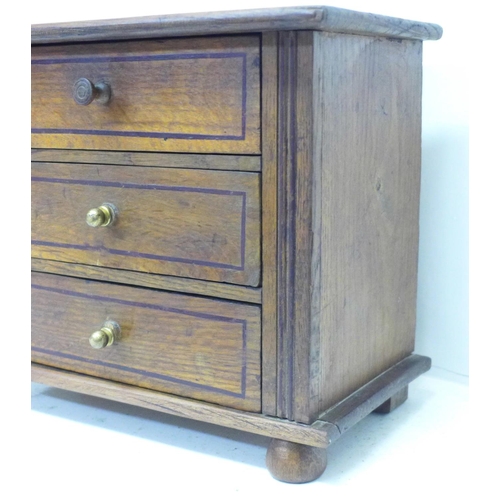 821 - A miniature oak chest of three drawers, 28cm x 23cm