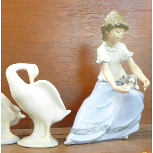 831 - Four Nao/Lladro figurines and one other, including “Girl with Goose and Dog”, “Girl with Puppy” and ... 