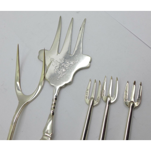 857 - A silver bread fork, Birmingham 1936, one other bread fork with silver covered handle and three silv... 