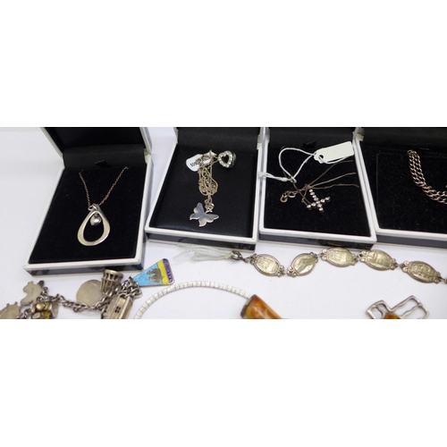 900 - A collection of mainly silver jewellery, etc., including two charm bracelets, chains, pendants inclu... 