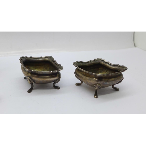 943 - A pair of silver salt and pepper pots, two silver salts and a silver mounted buffer by Goldsmiths & ... 