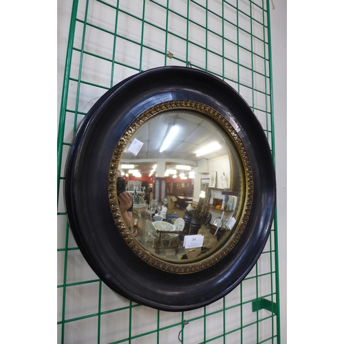 34 - A Victorian ebonised and parcel gilt convex mirror