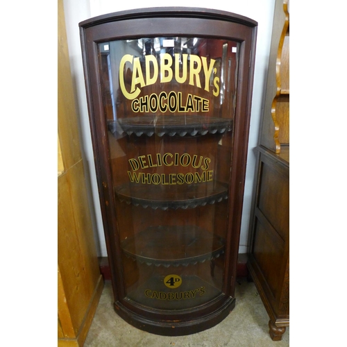 59 - A mahogany bow front freestanding corner shop cabinet, bearing later Cadbury's Chocolate inscription