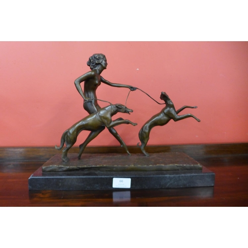 66 - An Art Deco style bronze figure of a female nude and two dogs, on black marble plinth