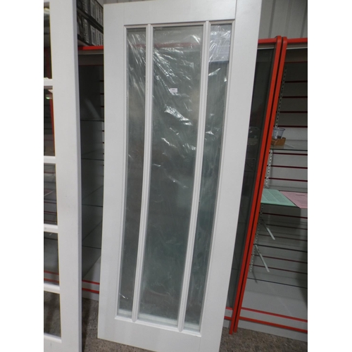 3002 - A pair of white primed timber internal doors with clear glass (1986x762x35mm) * this lot is subject ... 