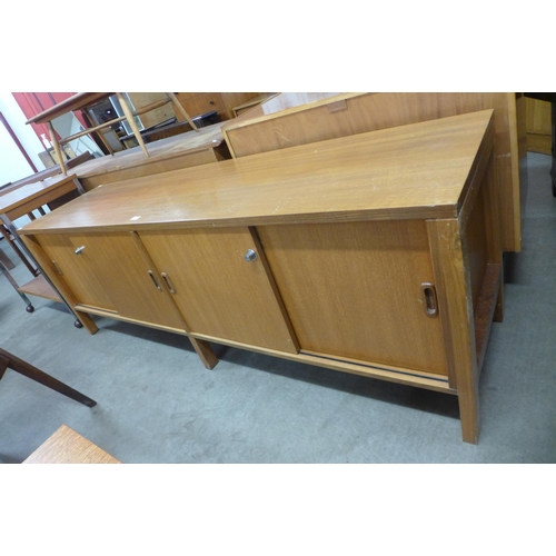 116 - A teak sliding two door sideboard