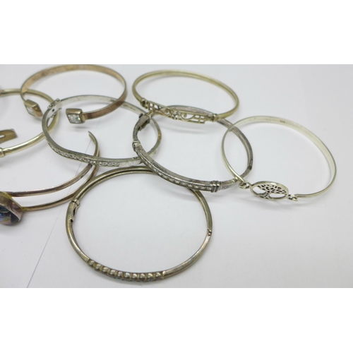 1046 - Seven silver bangles and three white metal bangles, total weight 117g