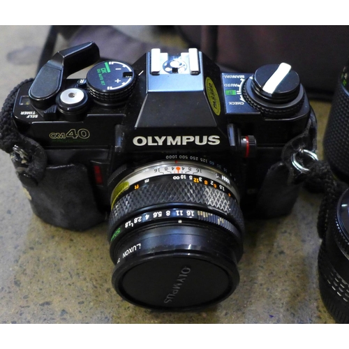 737 - Two Olympus cameras, OM10 and OM40 and five lenses including Olympus, Hanimex and Tokina